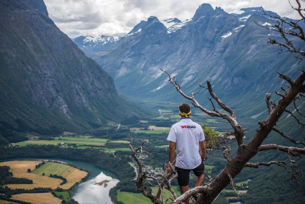 WeRoad traveler looking out over the Romsdalen valley from a mountain viewpoint in Norway.