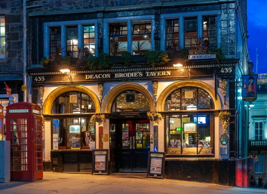 A Scottish restaurant at dusk with a traditional red telephone box in front.