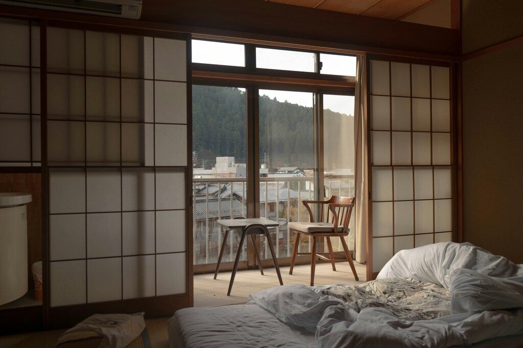 Traditional Japanese room with futon bed and mountain view through shoji doors