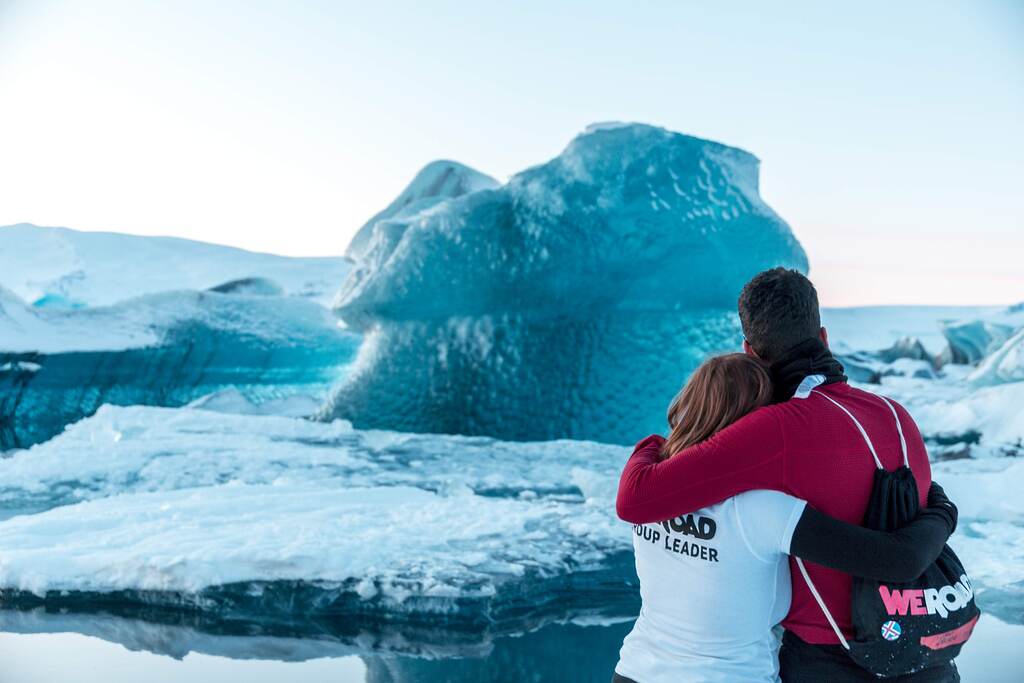 Two WeRoad travelers share an embrace while admiring the icebergs at Jökulsárlón Glacier Lagoon in Iceland.