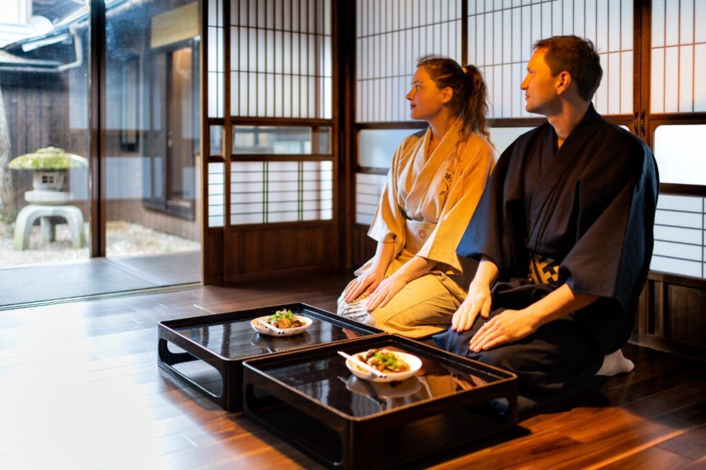 Couple wearing kimono kneeling for a meal in a traditional Japanese ryokan.