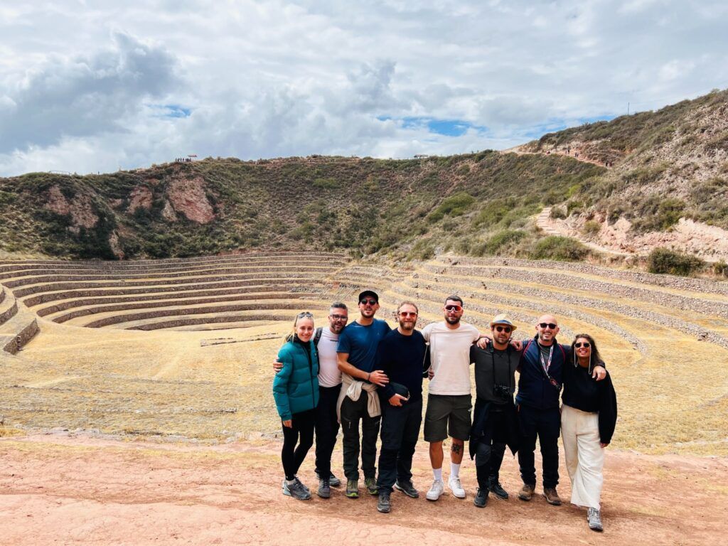WeRoad travelers posing in front of Moray Inca terraces.
