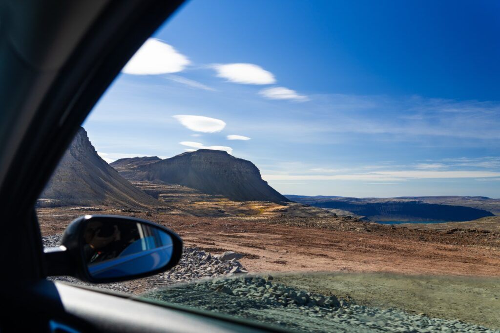 View of remote mountain pass and fjord from car window in Westfjords.