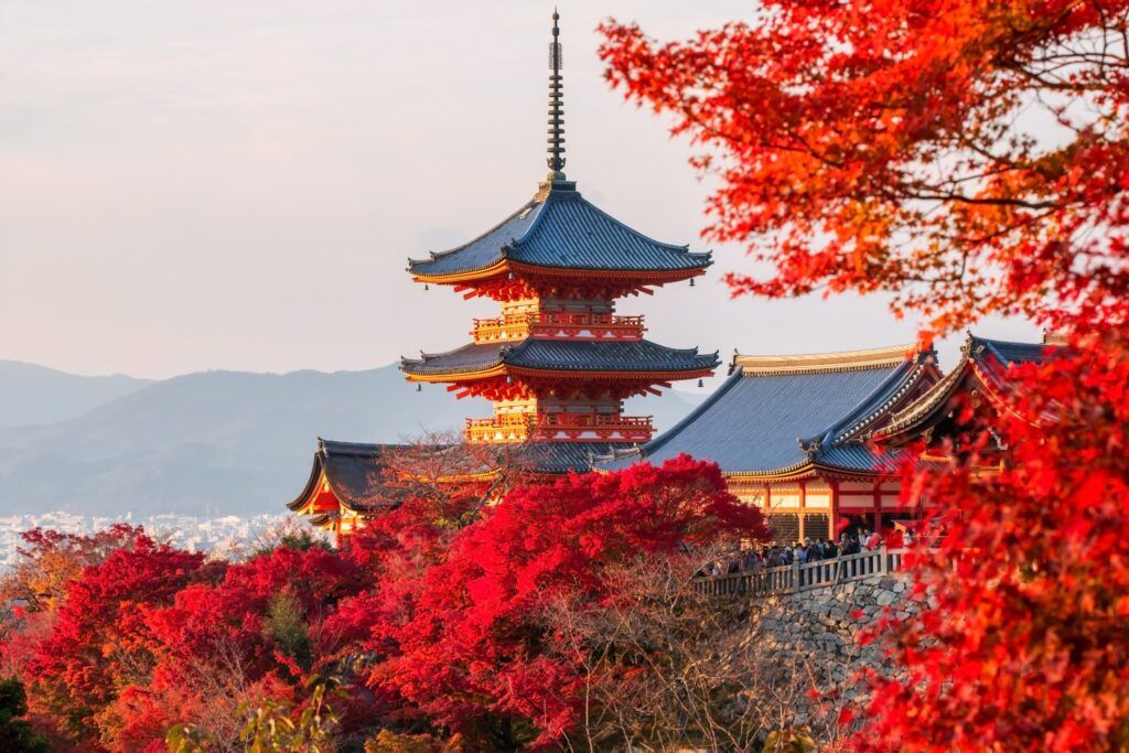 Kiyomizu-dera Temple pagoda surrounded by red autumn leaves.