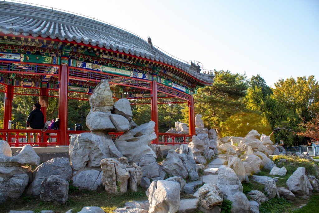 Traditional Chinese pavilion in a garden setting with decorative rock formations.