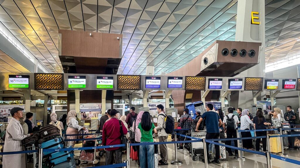 A check-in area at Jakarta’s Soekarno-Hatta International Airport (CGK) Terminal 3, featuring passengers queued with luggage.