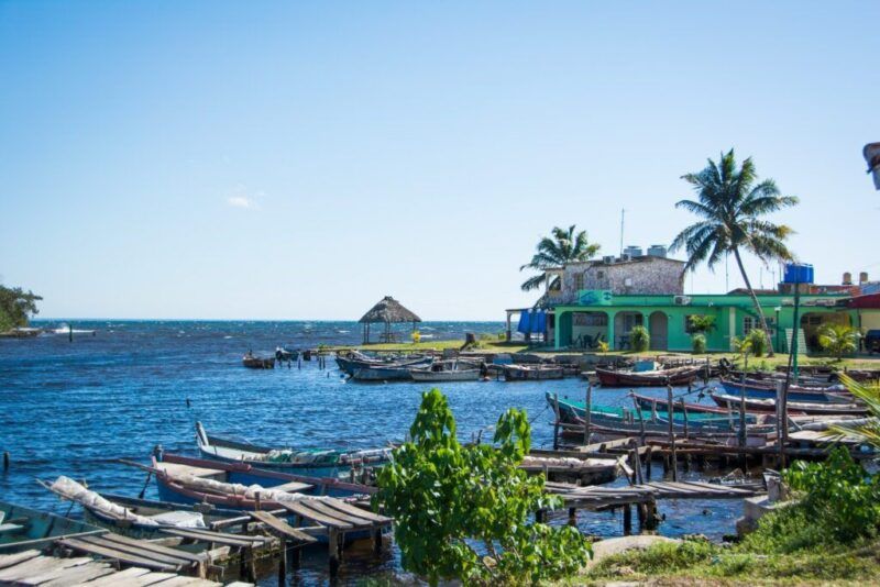 A line of small fishing boats docked along the shore of the deep blue sea in Playa Larga.