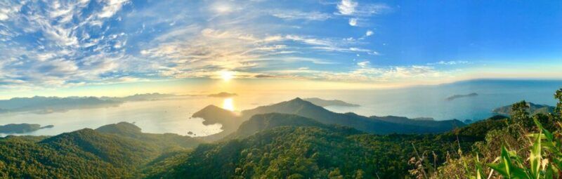A panoramic view at sunrise over the green mountains and coastal bays of Ilha Grande, Brazil.