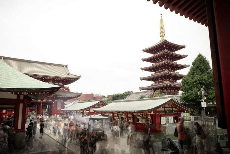 Five-story pagoda of Senso-ji Temple in Asakusa, Tokyo, with crowds walking among traditional Japanese rooftops