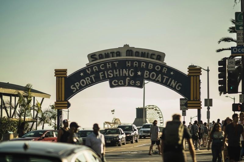 Santa Monica entrance with people and cars near the pier