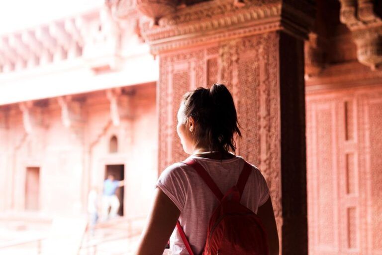 Young female traveler with backpack exploring a historic site.