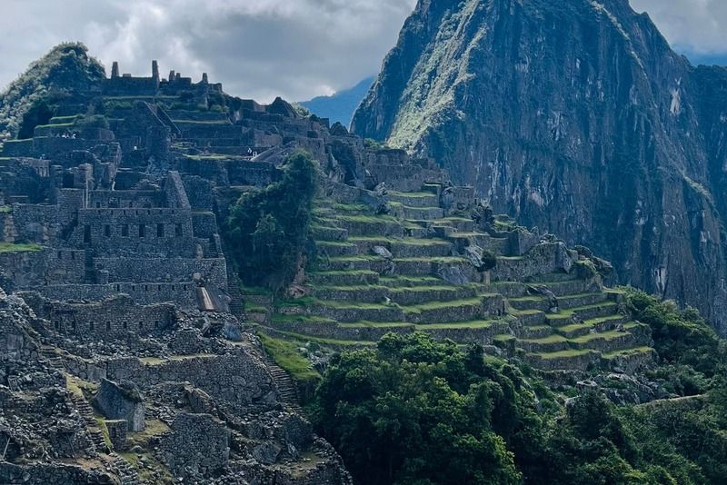 Ancient Inca ruins of Machu Picchu with Huayna Picchu mountain rising through the clouds in the Peruvian Andes