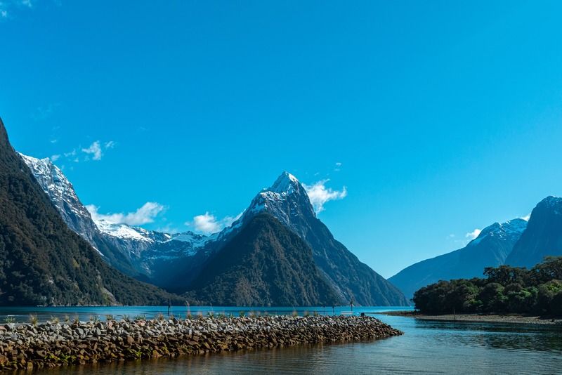 Serene fjord of Milford Sound with snow-capped Mitre Peak reflecting in the calm blue waters of New Zealand's South Island