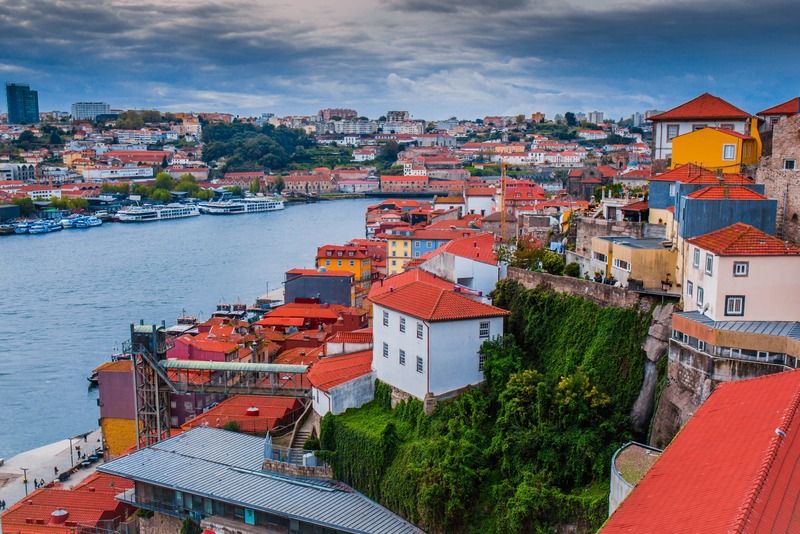 Colorful terracotta rooftops of Porto's Ribeira district overlooking the Douro River on a partly cloudy day, Portugal