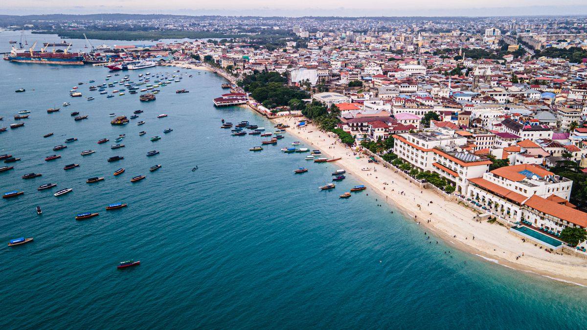 Aerial view of Stone Town coastline with boats along a wide sandy beach