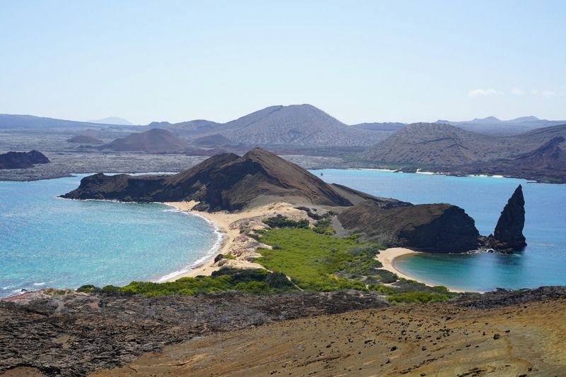 Aerial view of a volcanic island coastline with turquoise bays and dark lava rock formations