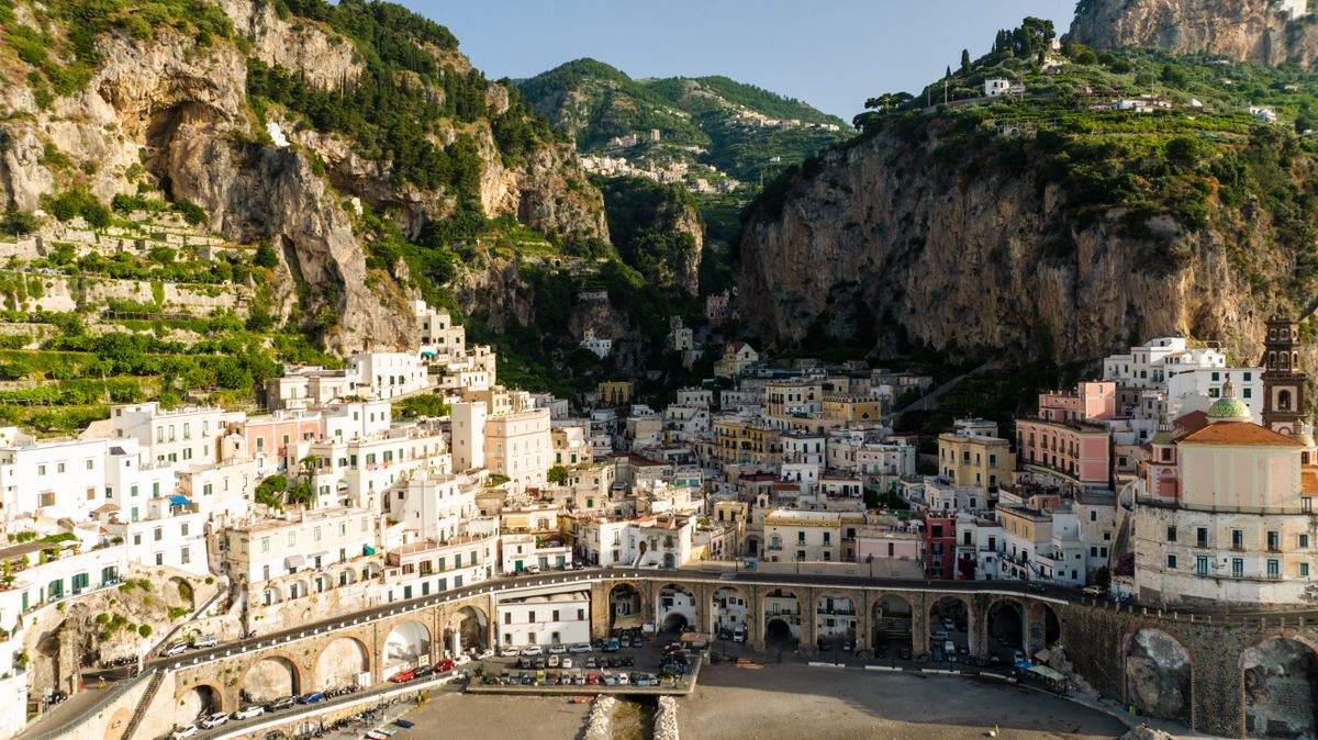 Amalfi town below towering cliffs with arcades and hillside buildings