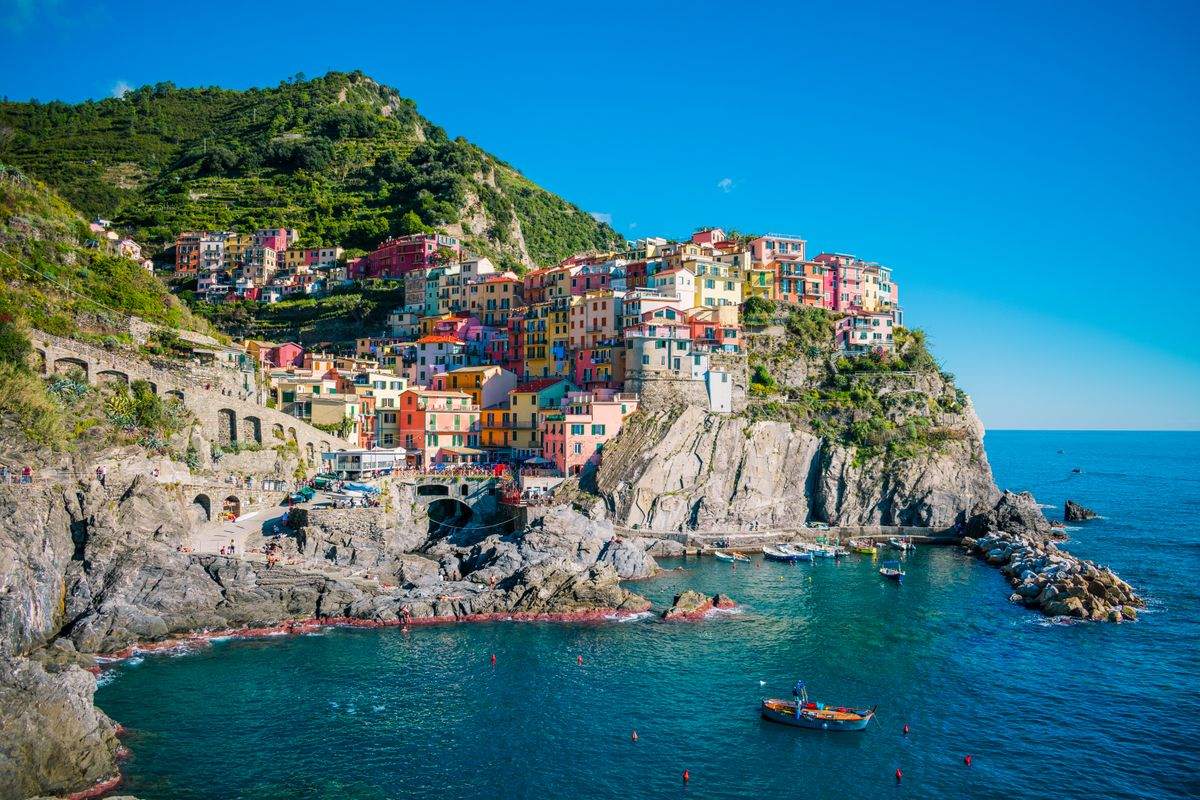 Colorful houses clustered on a rocky cliff above the sea in Manarola