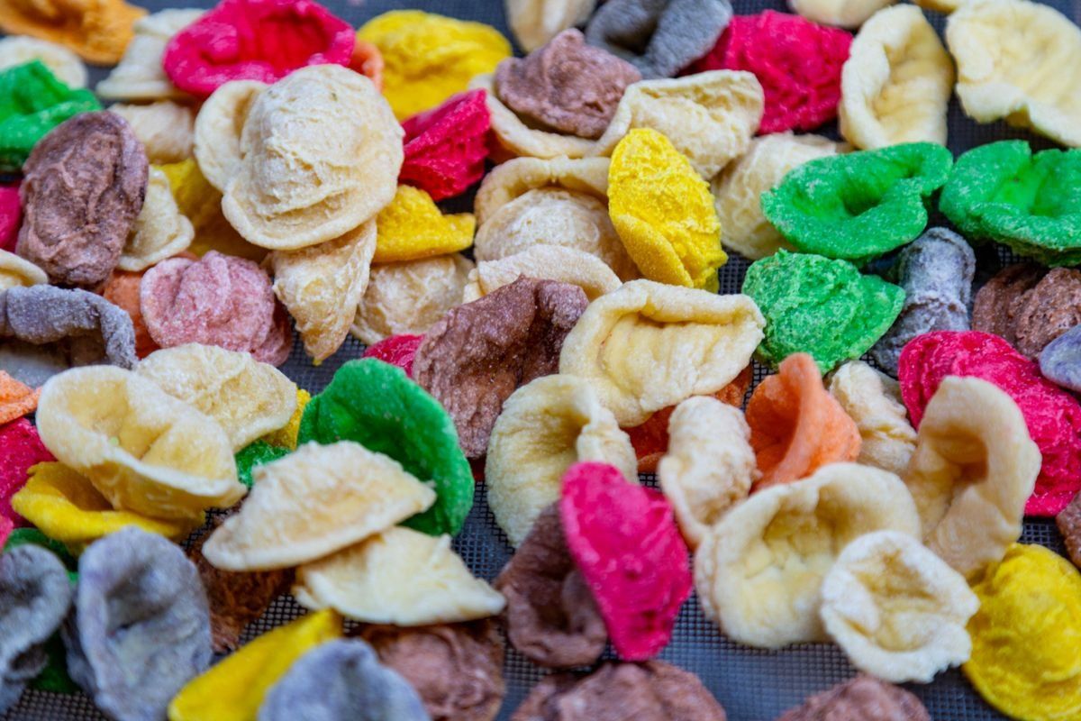Colorful orecchiette pasta spread across a drying rack