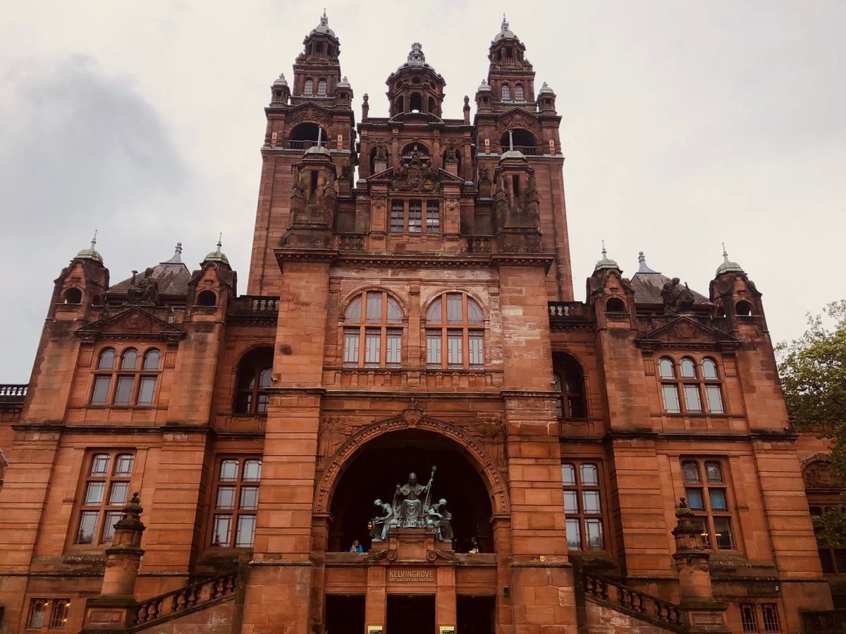 Front facade of Kelvingrove Art Gallery with towers and arched entrance under cloudy skies