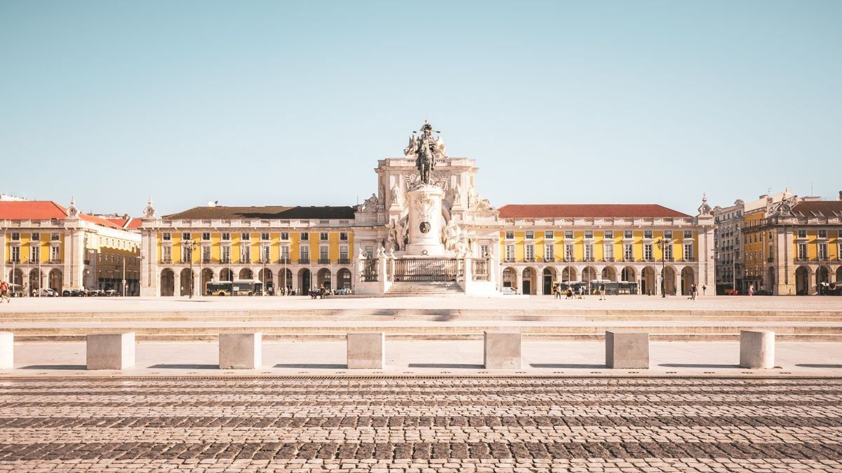 Praça do Comércio with its central statue and arcaded buildings under a clear sky