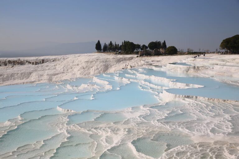 White travertine pools filled with turquoise water at the Pamukkale thermal springs in Denizli, Turkey