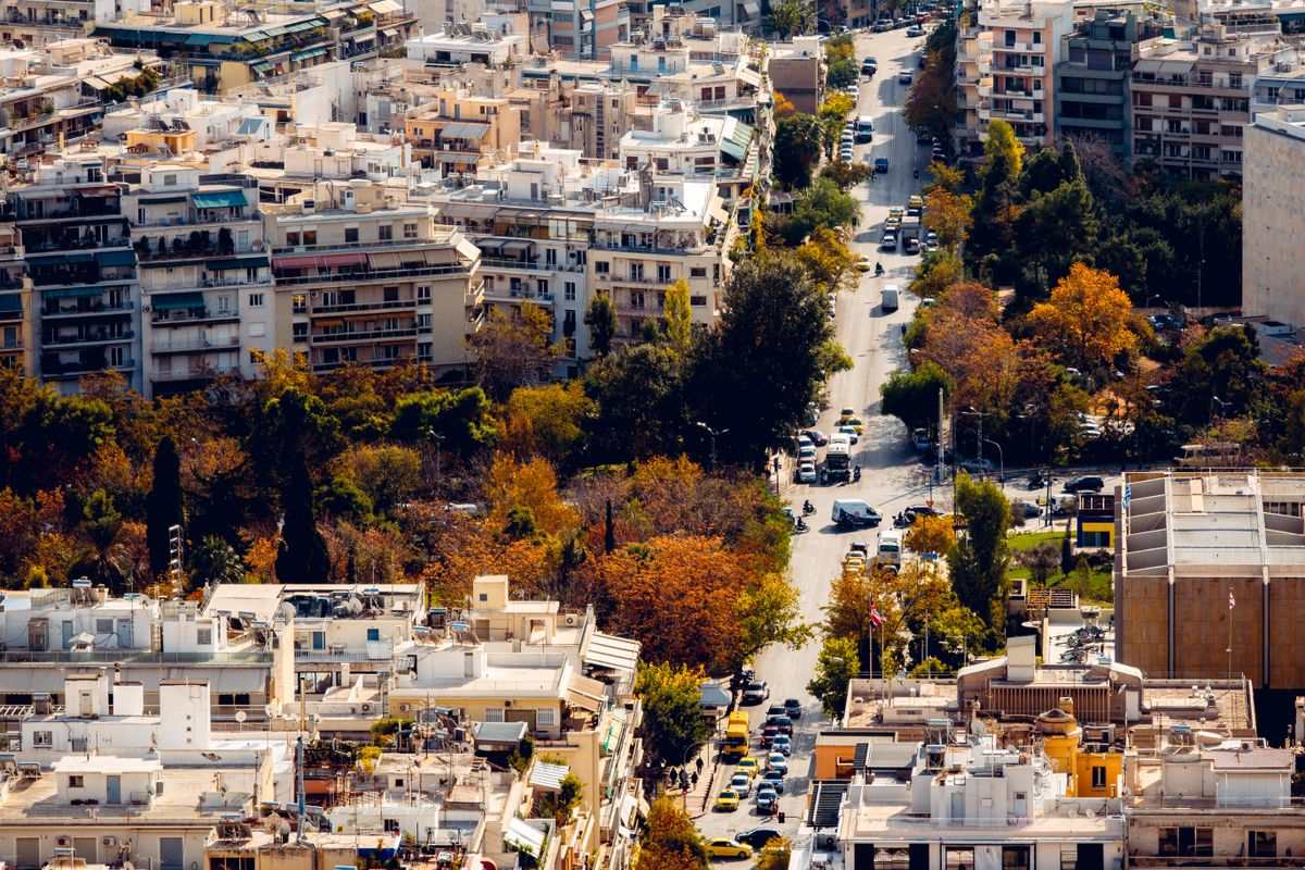 Aerial view of Athens streets lined with autumn trees and apartment buildings