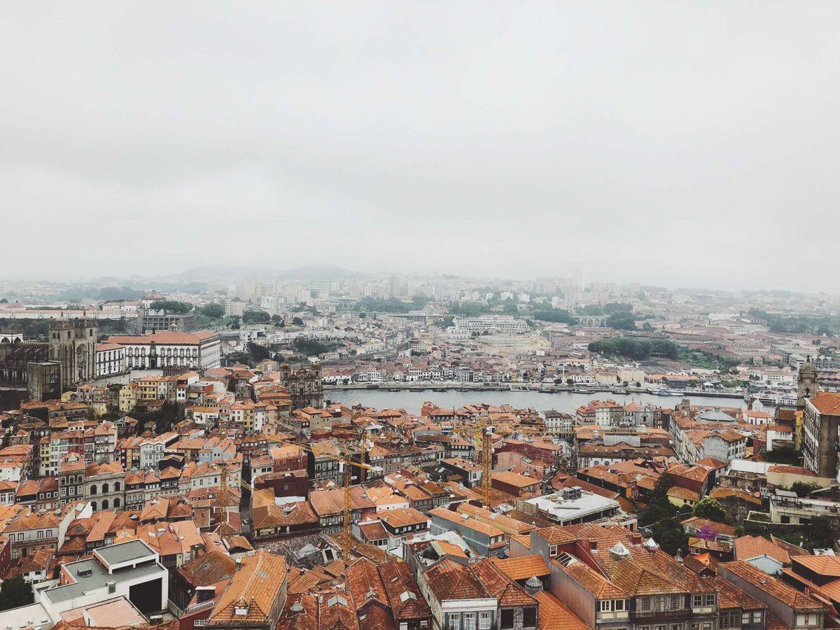 Aerial view of Porto rooftops and the Douro River under a misty sky