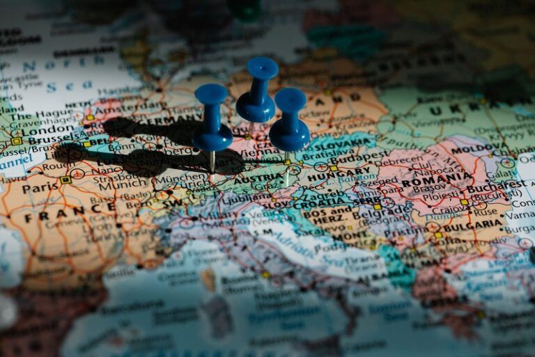 Three blue pushpins marking travel destinations on a map of Central Europe