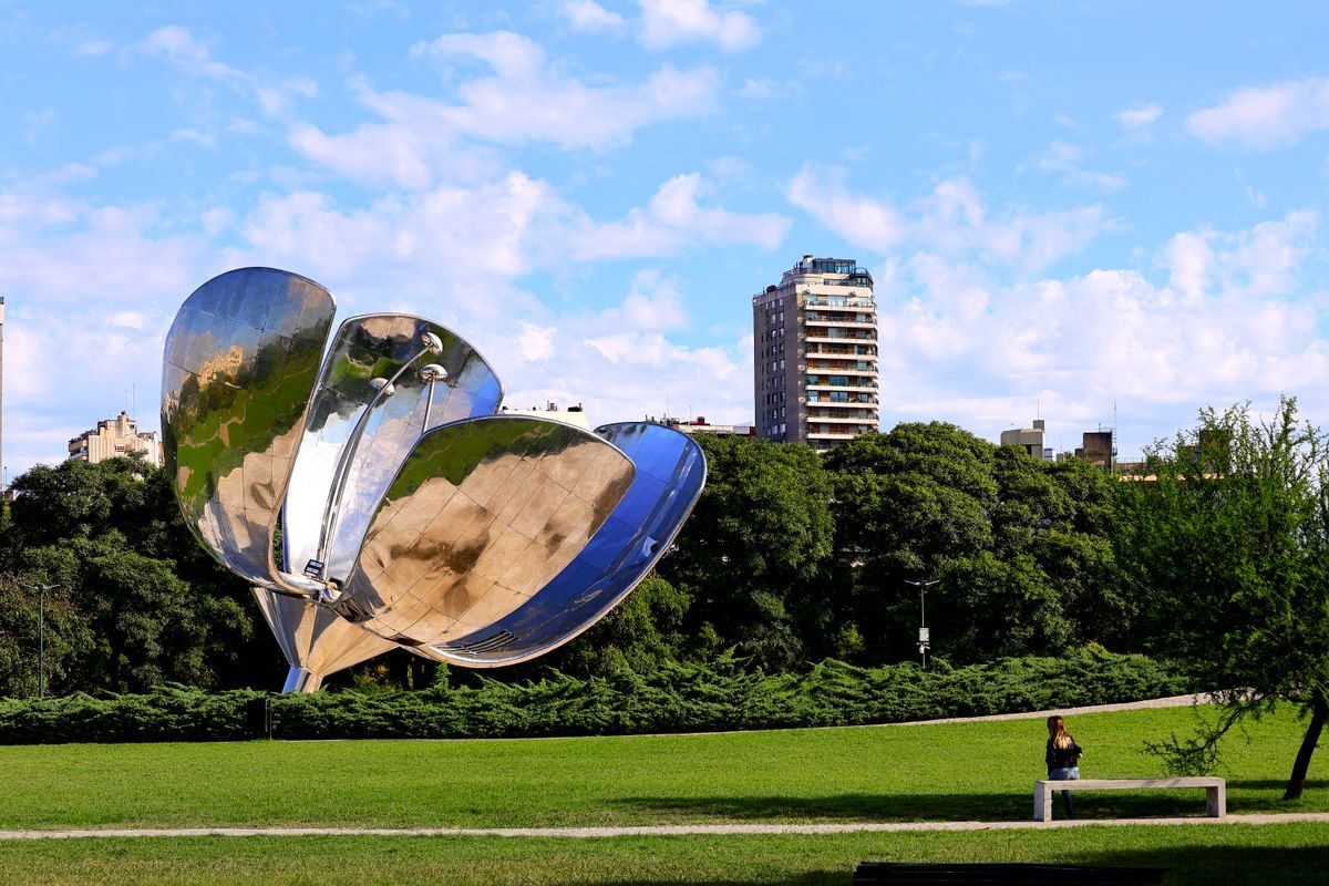 Floralis Generica sculpture in a green Buenos Aires park with buildings behind