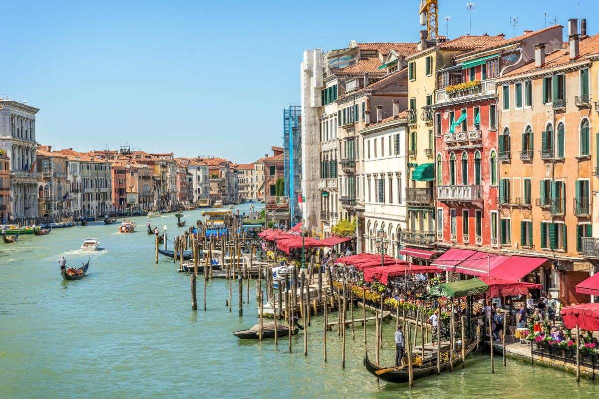 Grand Canal in Venice with gondolas, wooden mooring poles, and colorful waterfront buildings