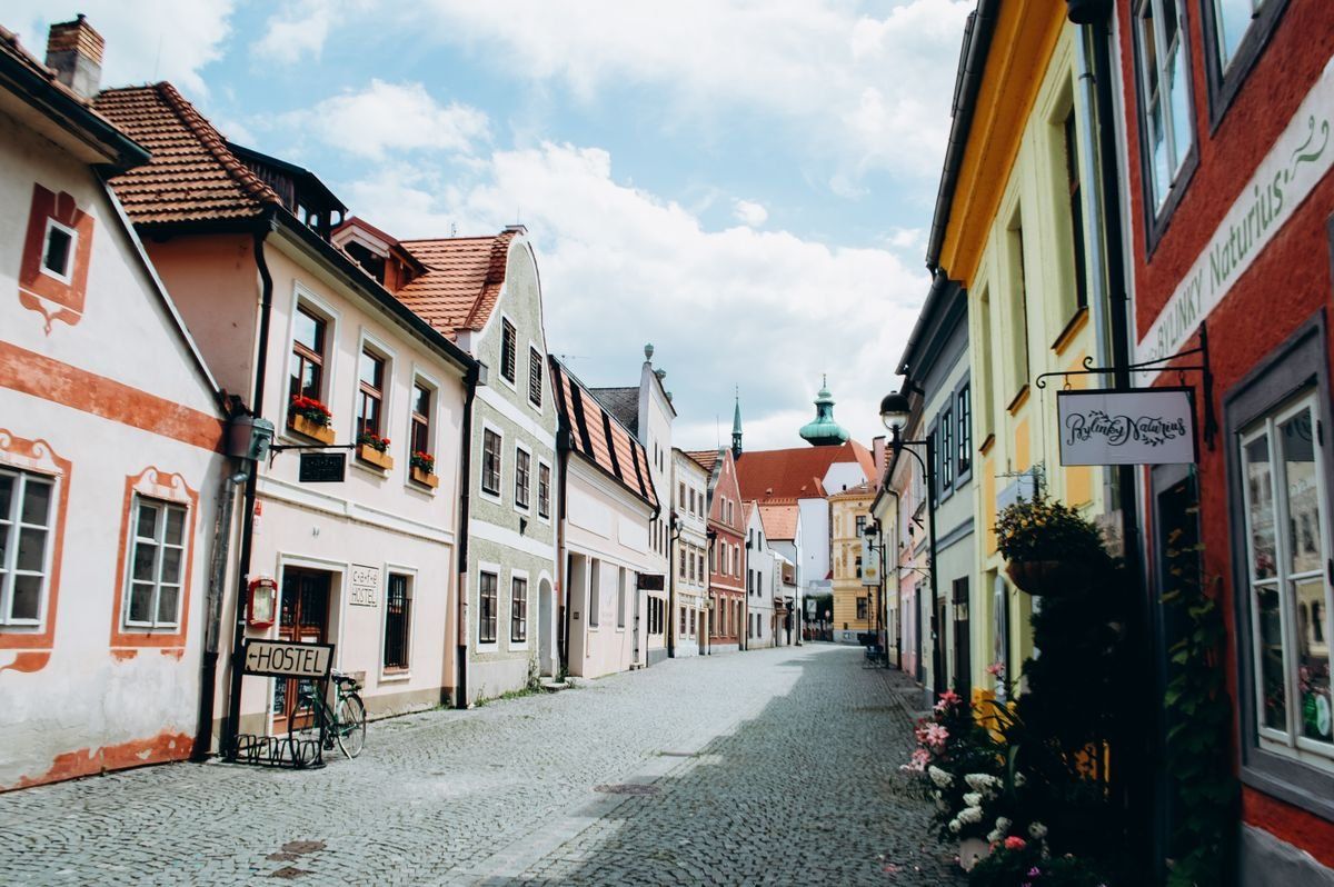 Quiet cobblestone street with colorful old buildings and shop signs in a European town