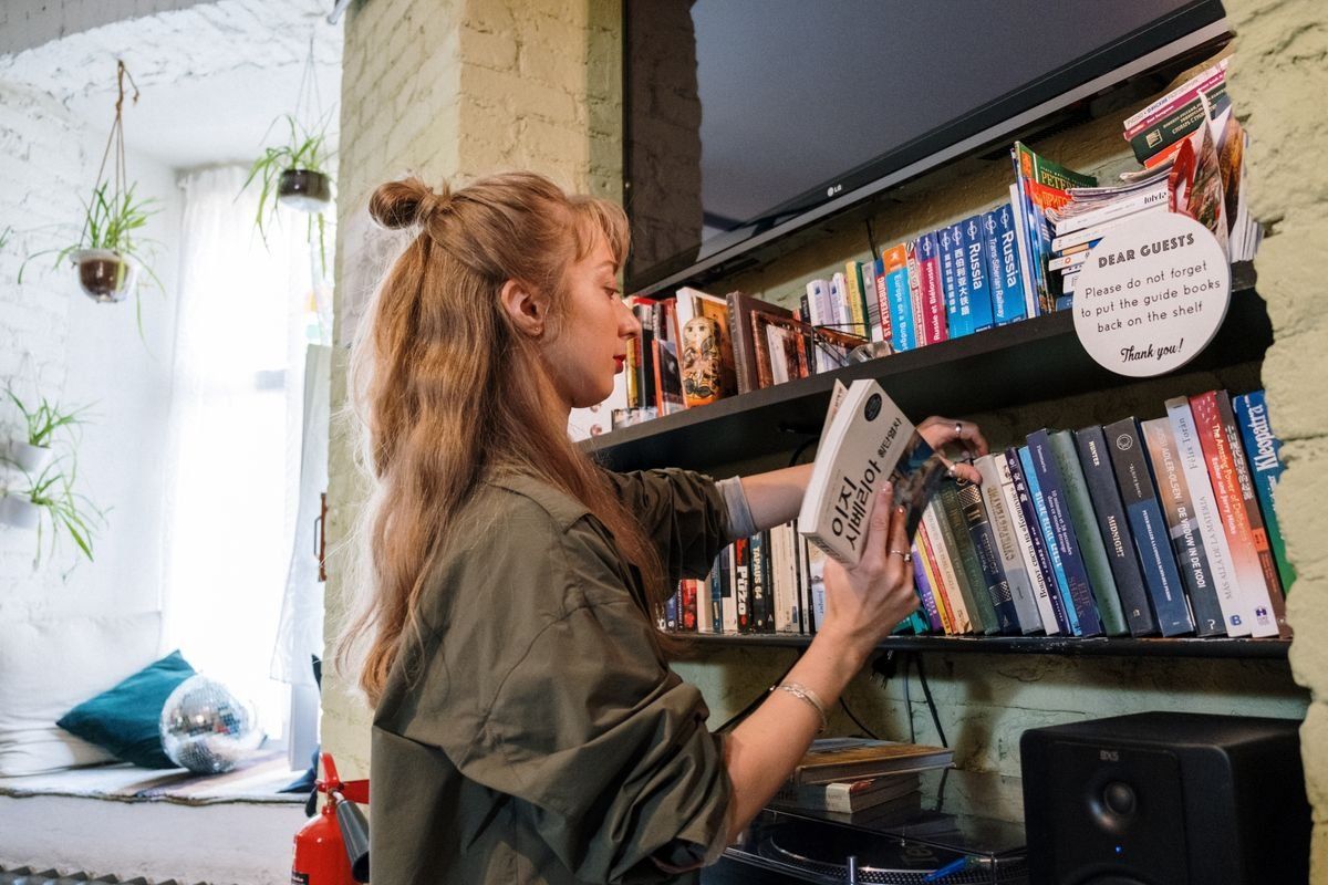 Woman choosing a book from a shelf in a cozy common area