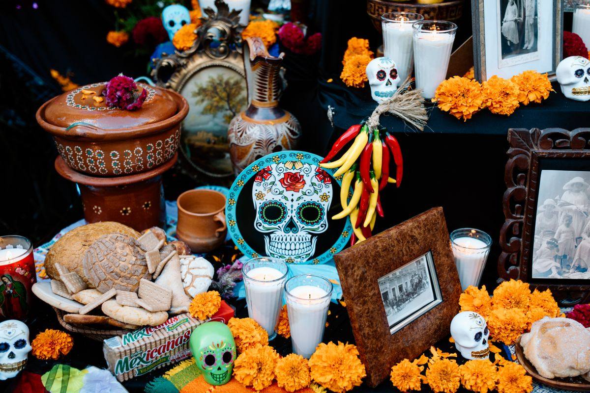 Day of the Dead altar with candles, marigolds, skulls, bread and framed photos