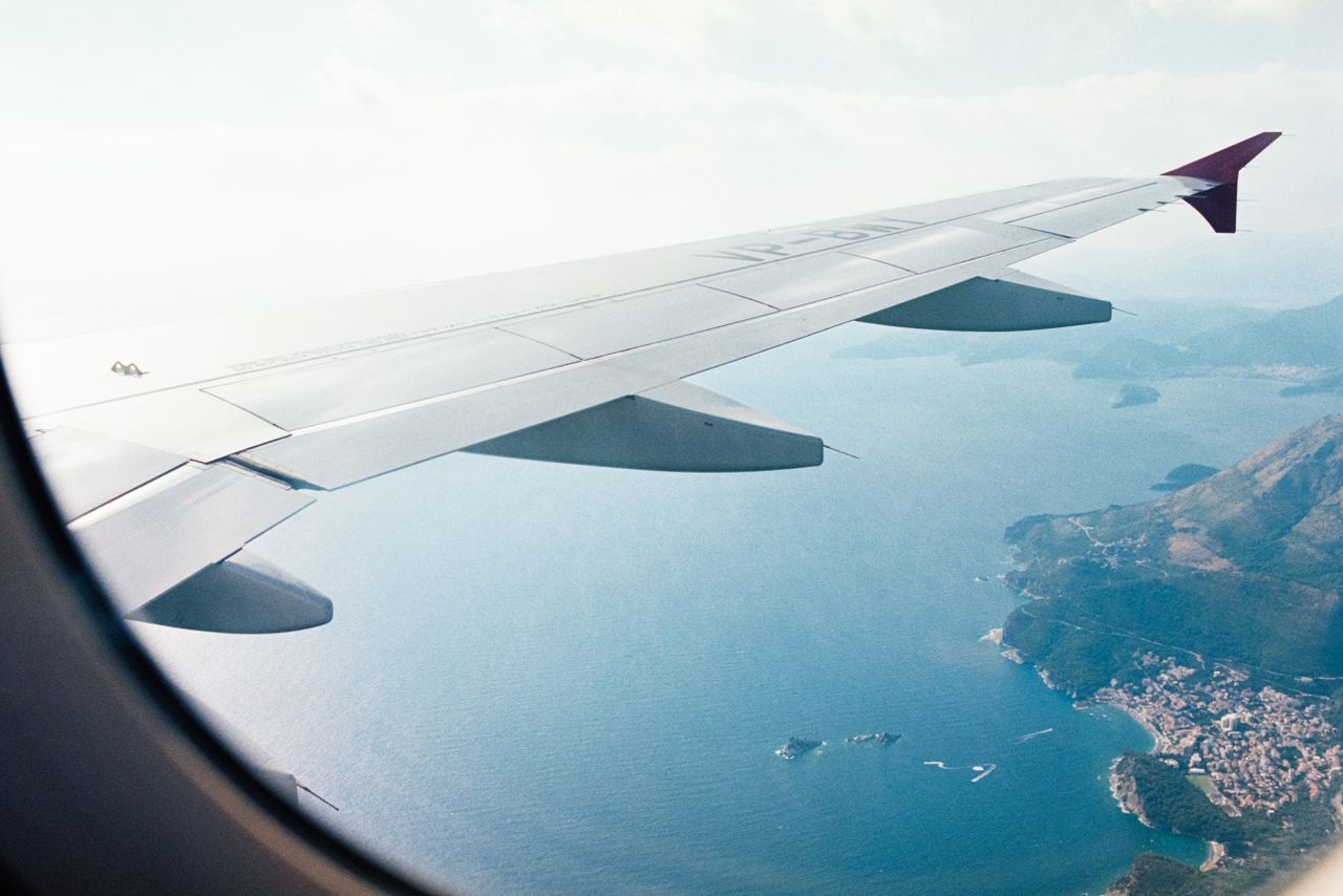 Black Friday flight deals: airplane wing flying over the coast