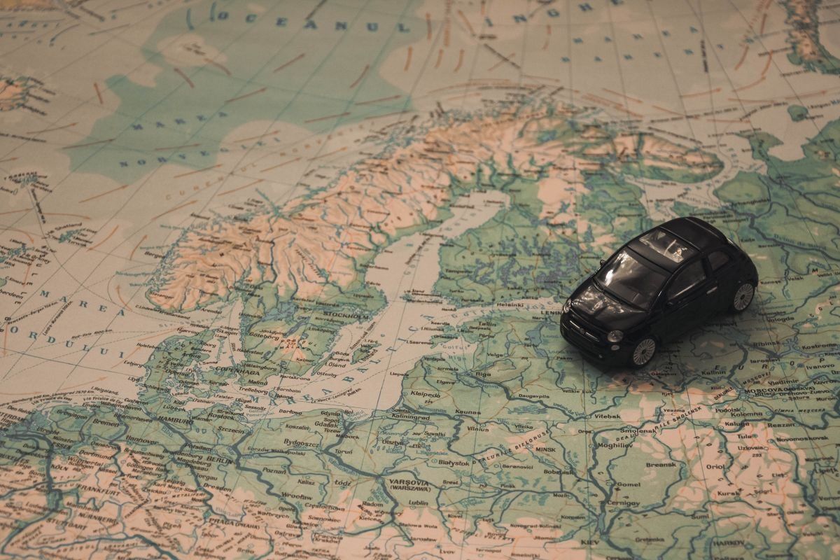 Black toy car placed on a detailed map of Scandinavia