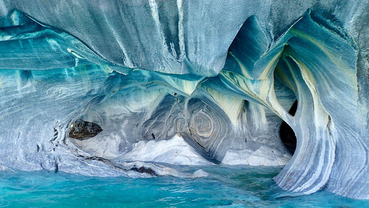 Blue marble cave formations above turquoise water in Patagonia
