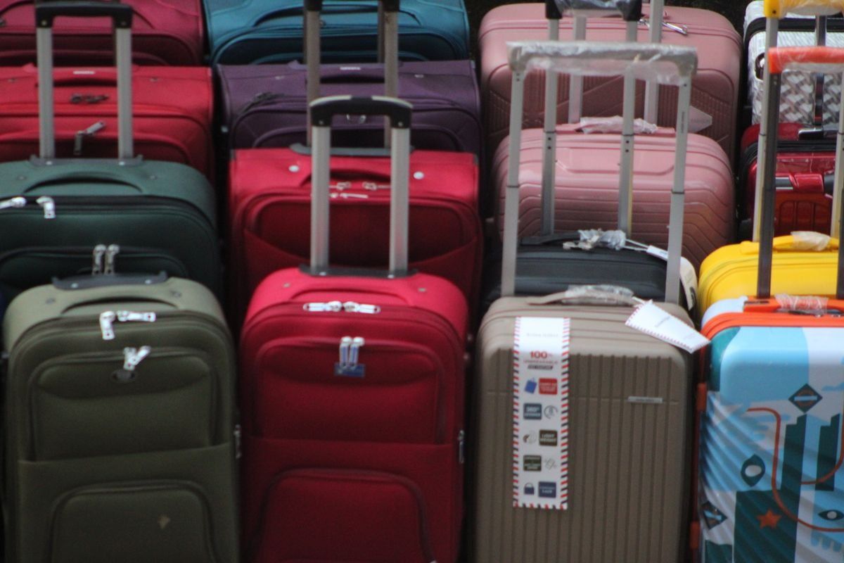 Colorful suitcases with extended handles lined up closely together
