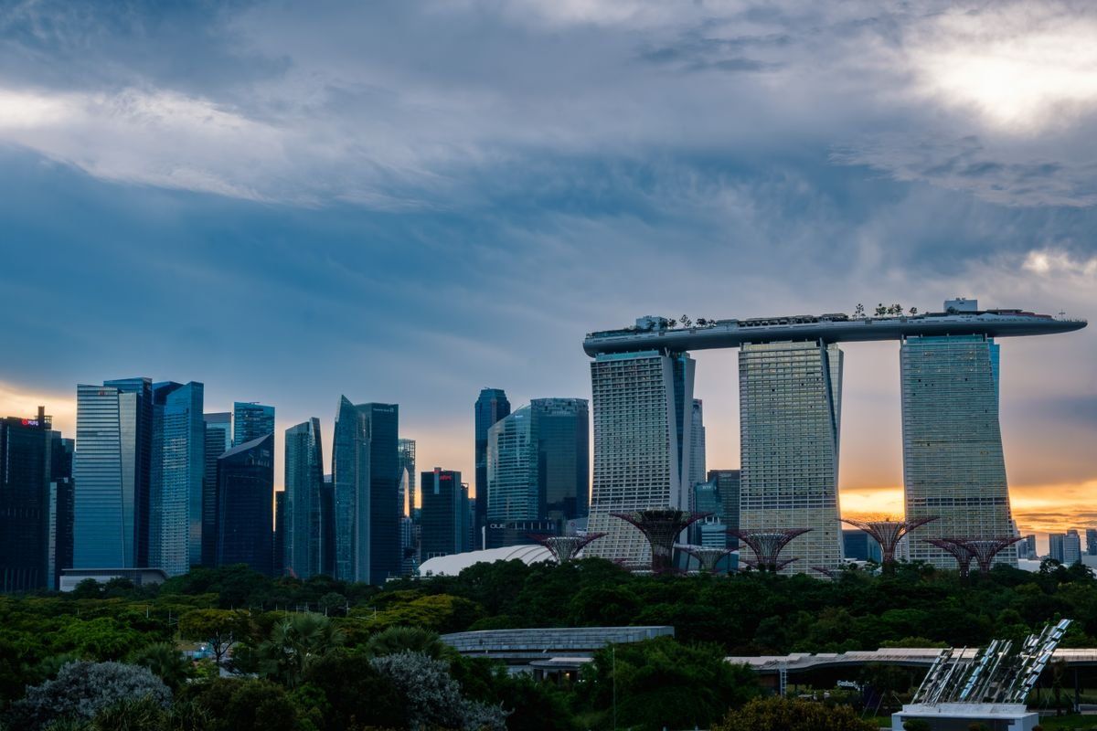 Marina Bay Sands and Singapore skyline at sunset under a cloudy sky