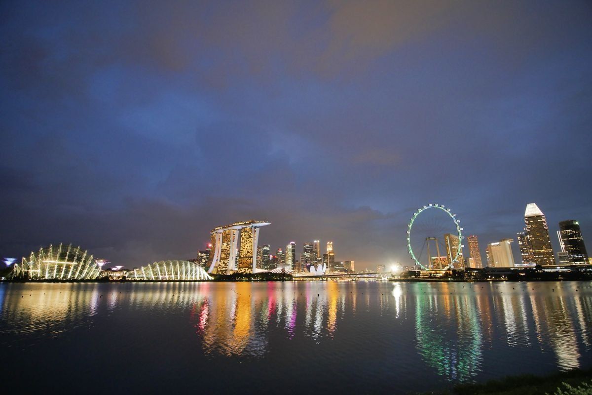 Marina Bay skyline at night with illuminated buildings reflected on the water