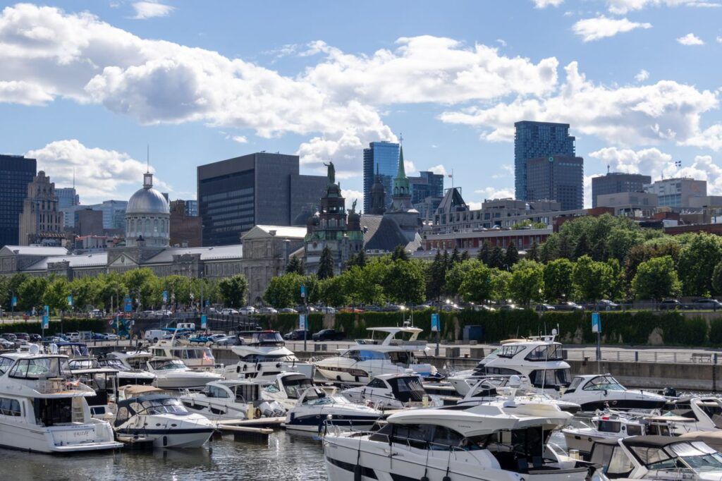 Boats in the marina of the Old Port of Montreal with the city skyline behind