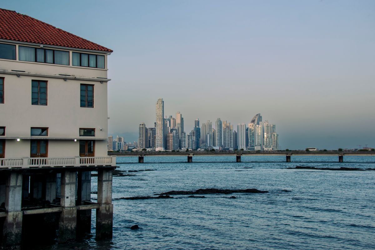Panama City skyline across the water beside a white waterfront building at dusk