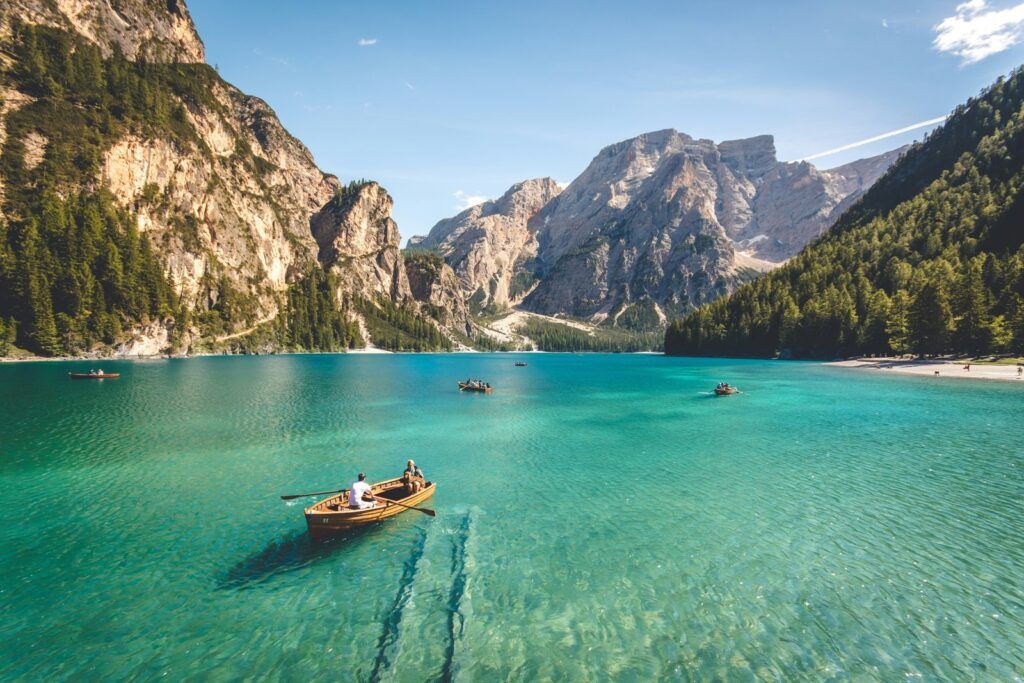 Rowboats on a turquoise alpine lake surrounded by mountains