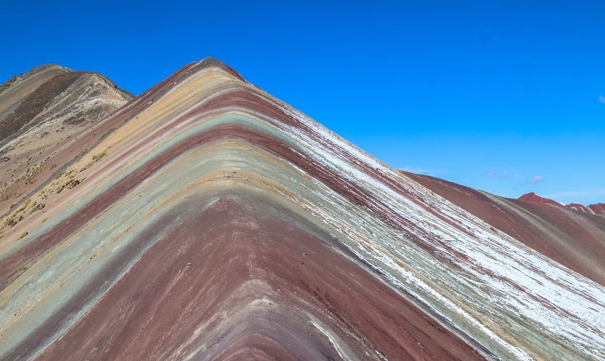 Striped slopes of Rainbow Mountain under a clear blue sky