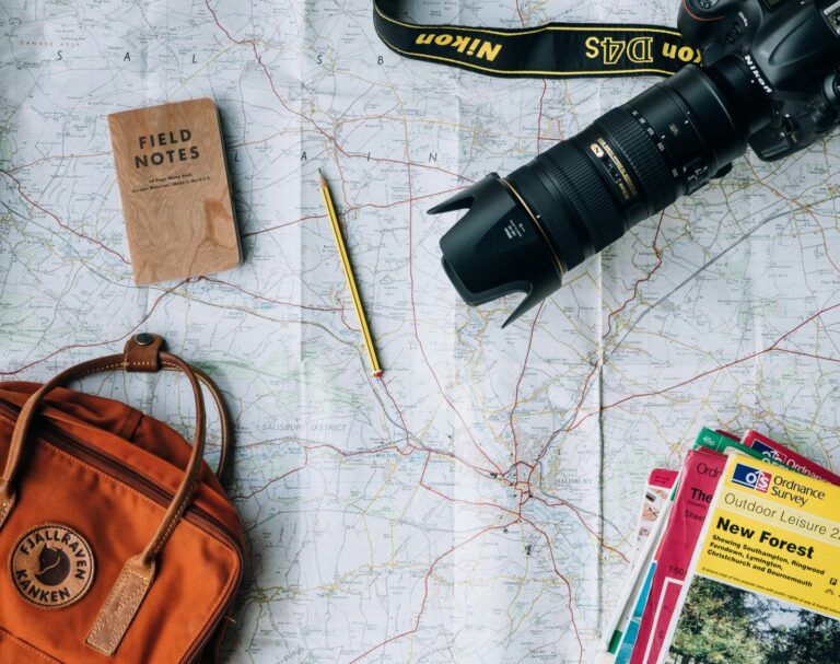 Map, camera, notebook and backpack ready to plan a trip