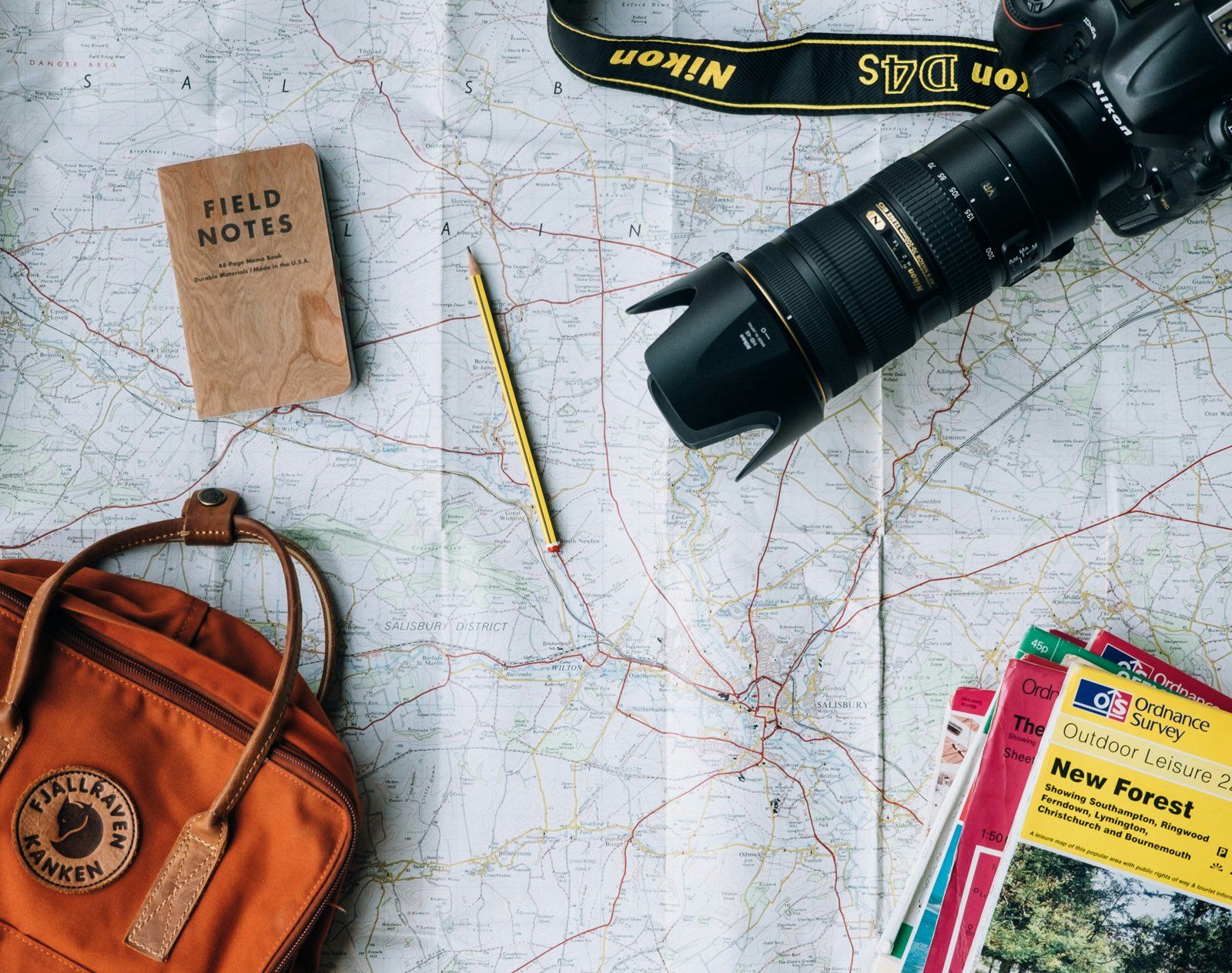 Map, camera, notebook and backpack ready to plan a trip