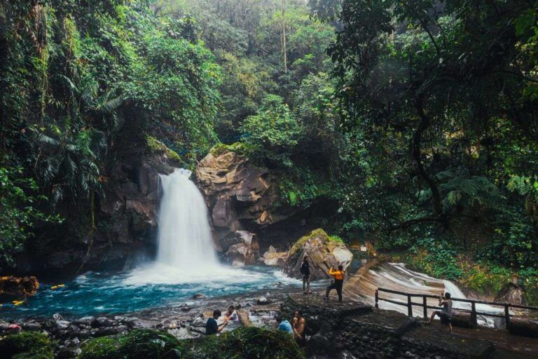Is Costa Rica safe: travelers at a waterfall in the tropical rainforest of Costa Rica