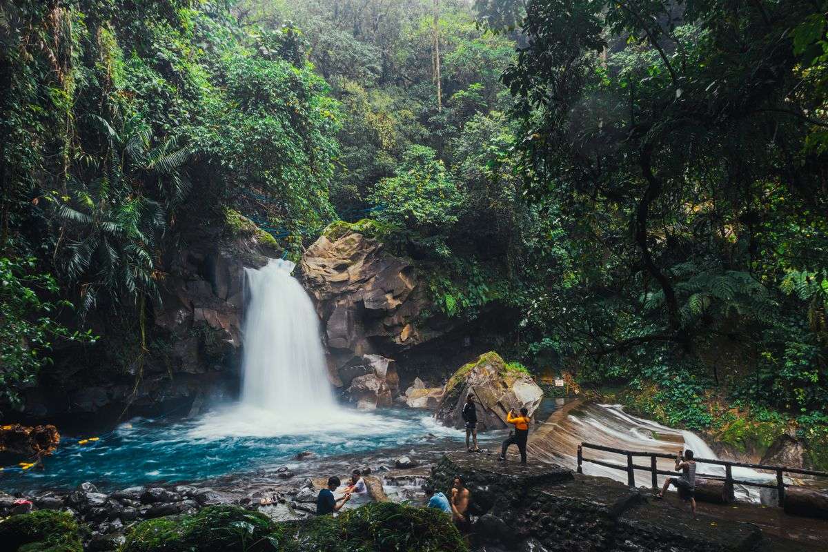 Is Costa Rica safe: travelers at a waterfall in the tropical rainforest of Costa Rica