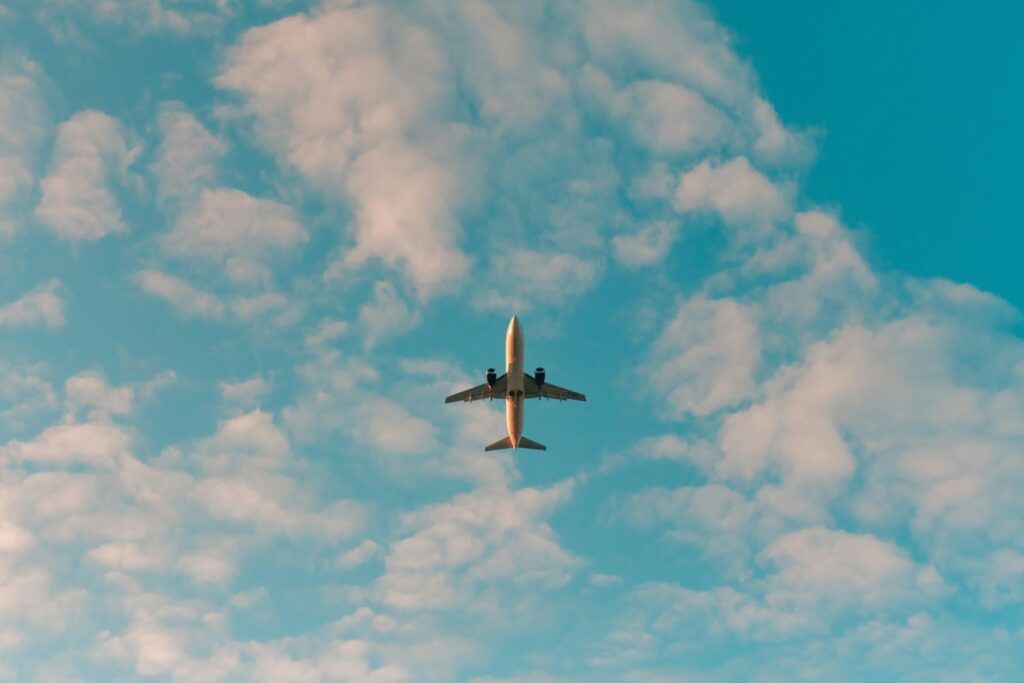 Airplane flying in a blue sky with clouds